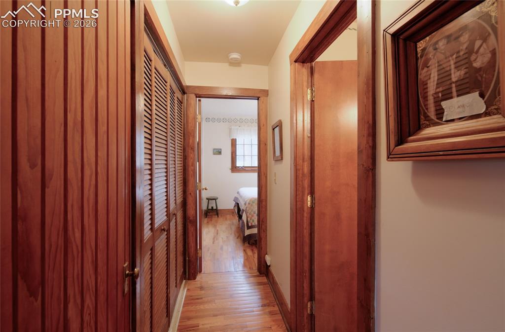 Image 14 of 33: Hallway to guest bedroom and bath. One your left is a coat closet and Washe