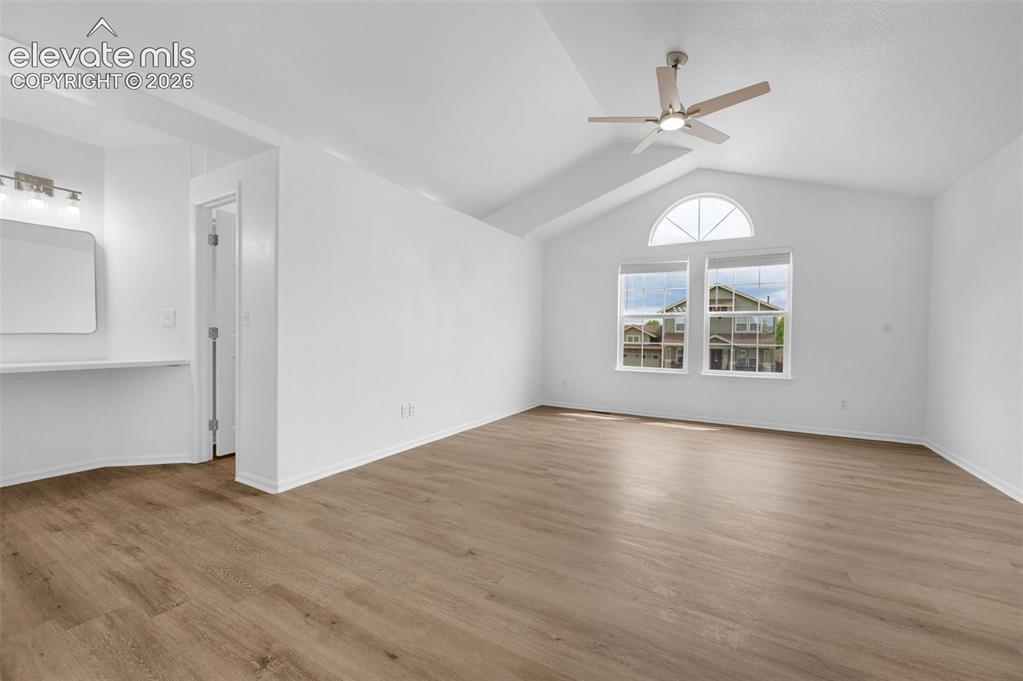 Image 20 of 35: Open loft space featuring wood-finish flooring and a white color palette