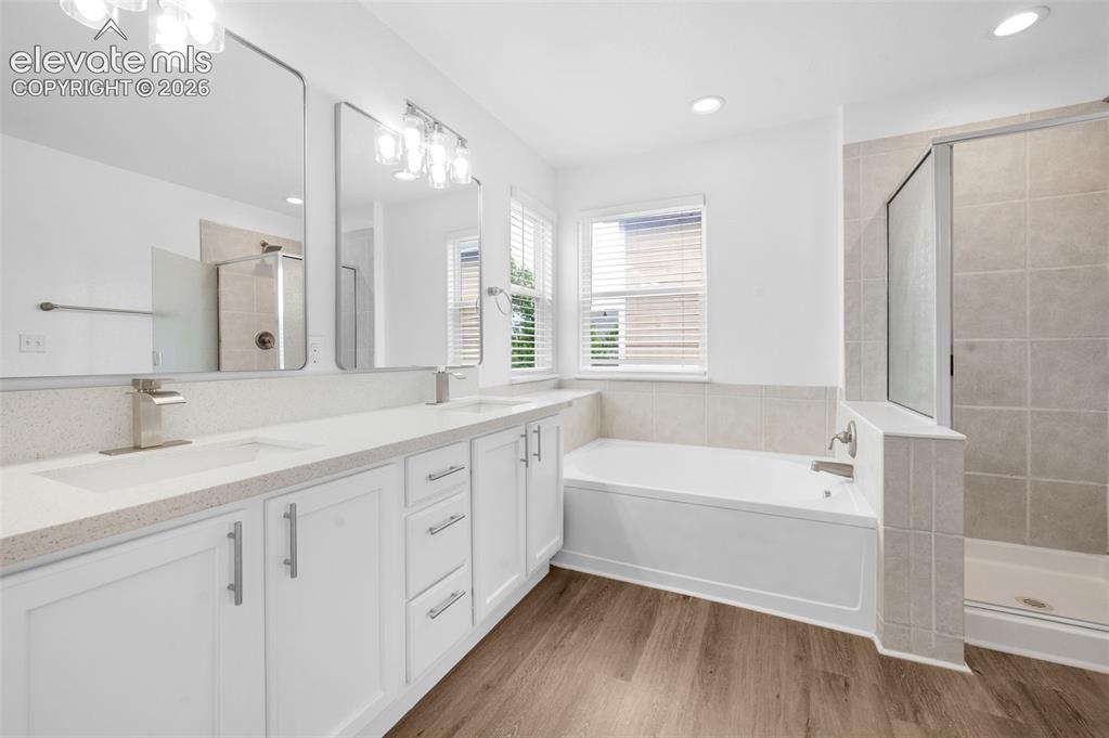 Image 23 of 35: Walk-in closet featuring built-in shelving, double hanging rods, white wall