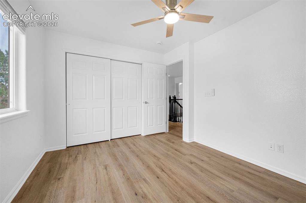 Image 25 of 35: Expansive window providing natural light, wood-finish flooring, white baseb