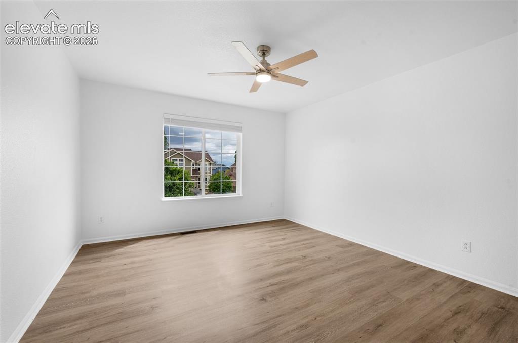 Image 26 of 35: Neutral tone wood-finish flooring complements white walls