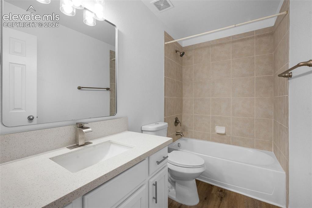 Image 28 of 35: Light wood-finish flooring complements the neutral wall tones