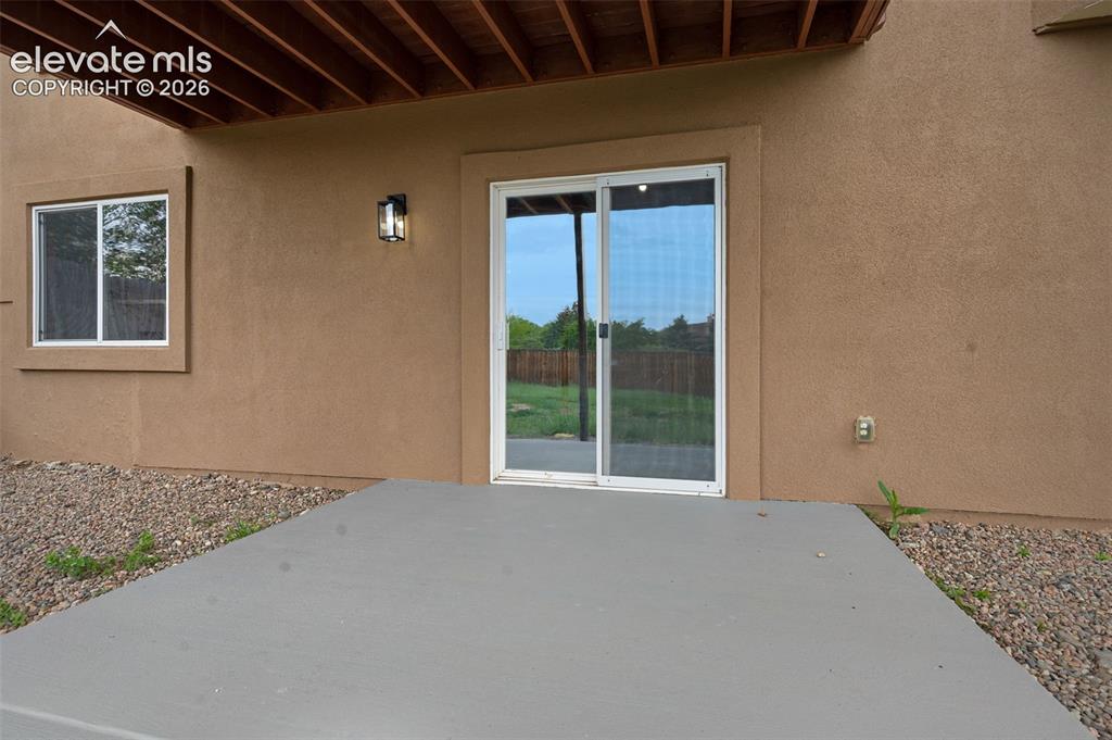 Image 32 of 35: Spacious backyard featuring a multi-level deck, a ground-level concrete pat