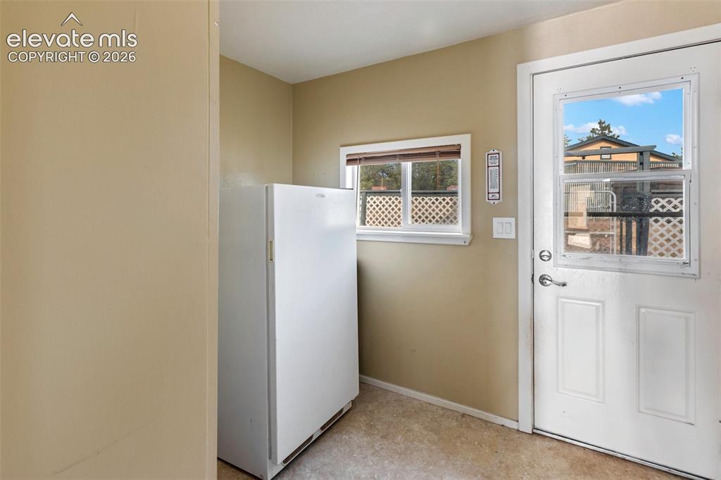 Image 31 of 50: Mudroom entry area with freezer and storage