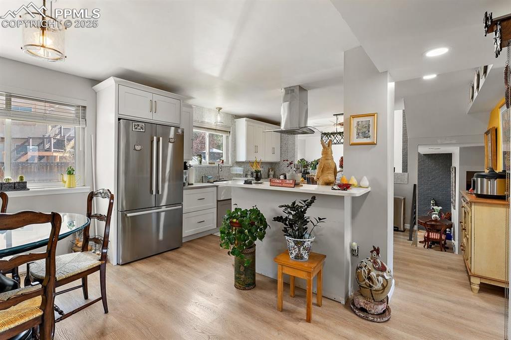 Image 12 of 41: Kitchen with high end refrigerator, tasteful backsplash, light wood finishe
