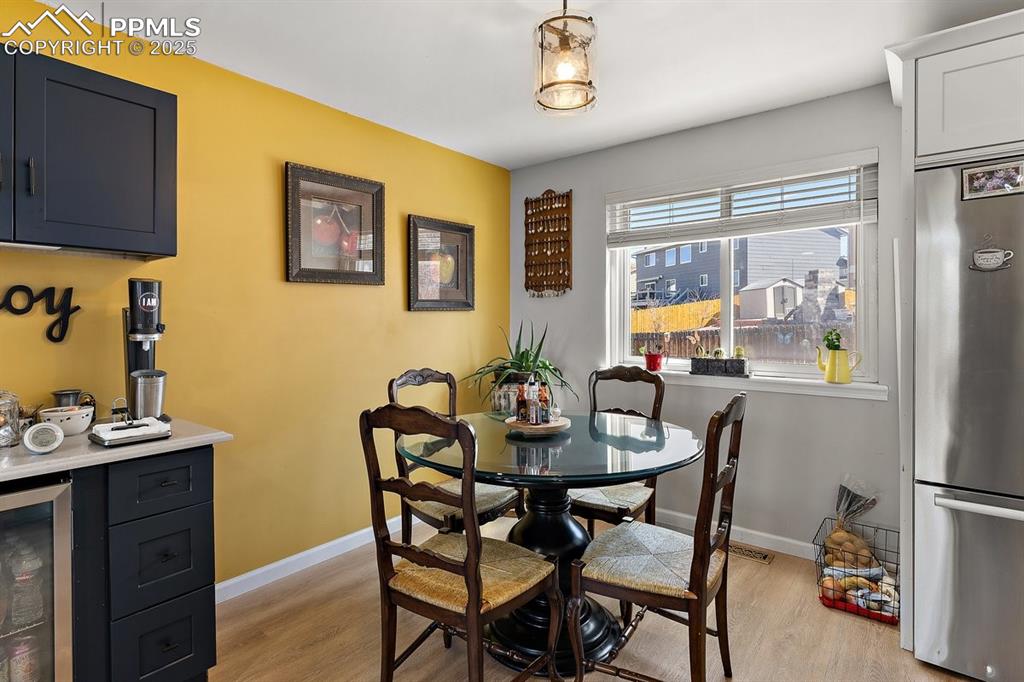 Image 13 of 41: Dining area with light wood-type flooring and wine cooler