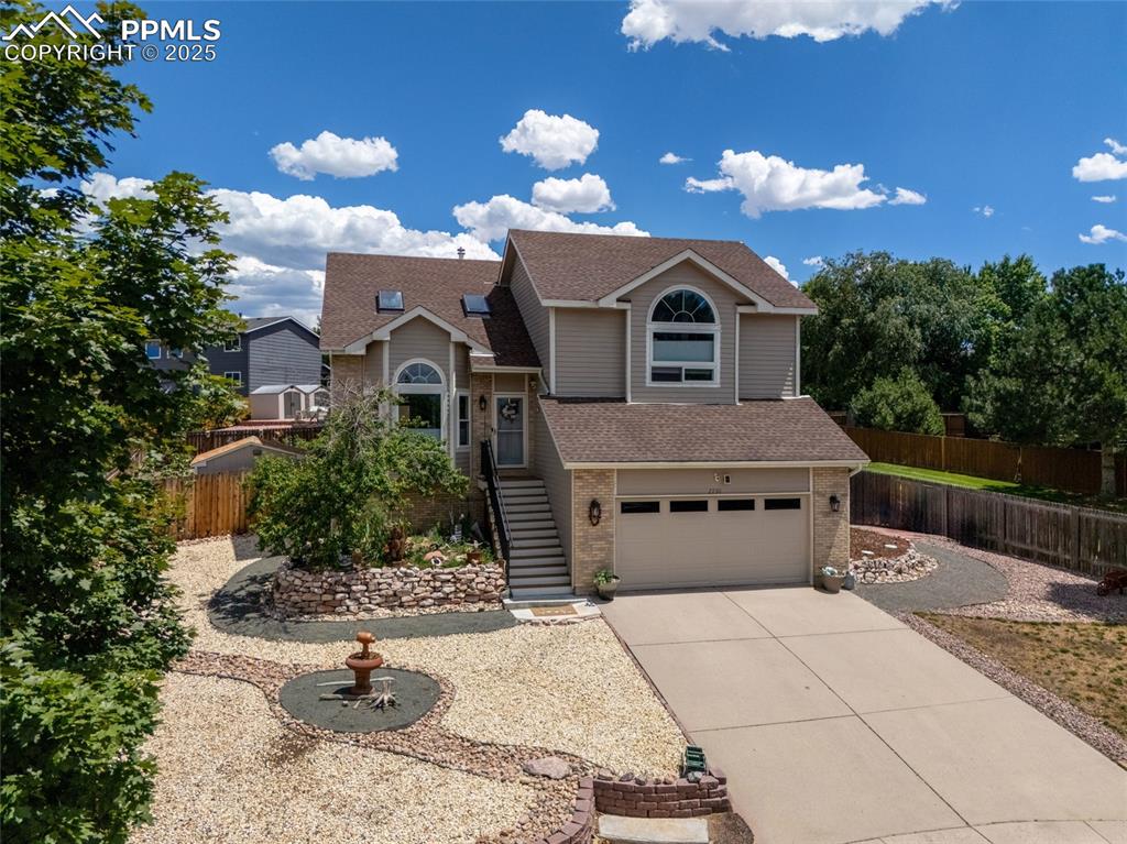 Image 2 of 41: View of front of home with driveway, a shingled roof, a garage, and brick s