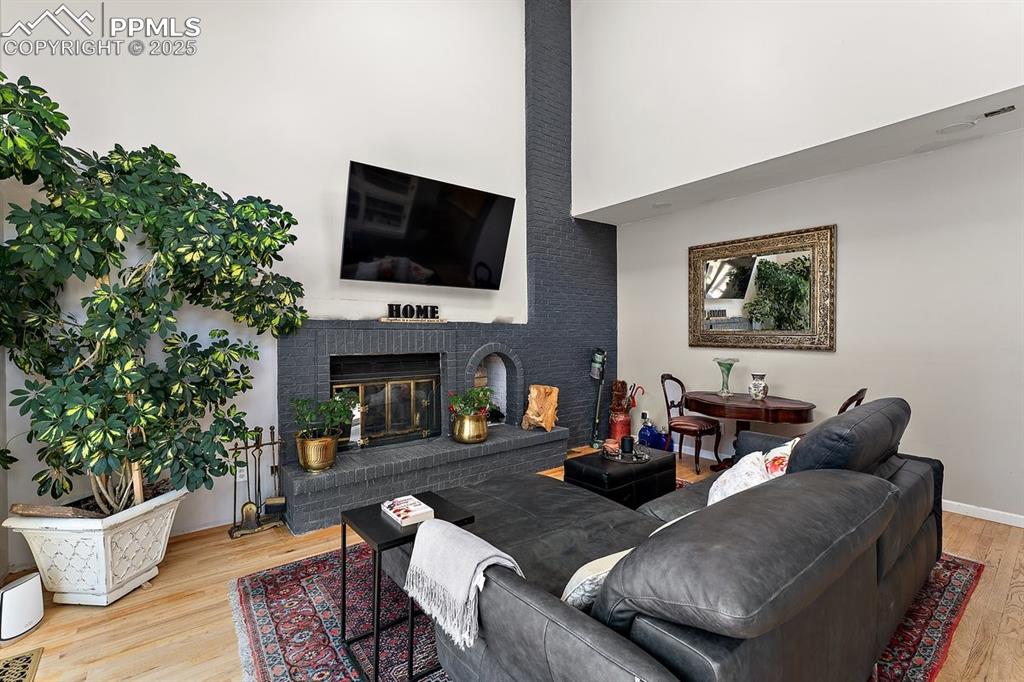 Image 20 of 41: Living area featuring wood finished floors and a fireplace