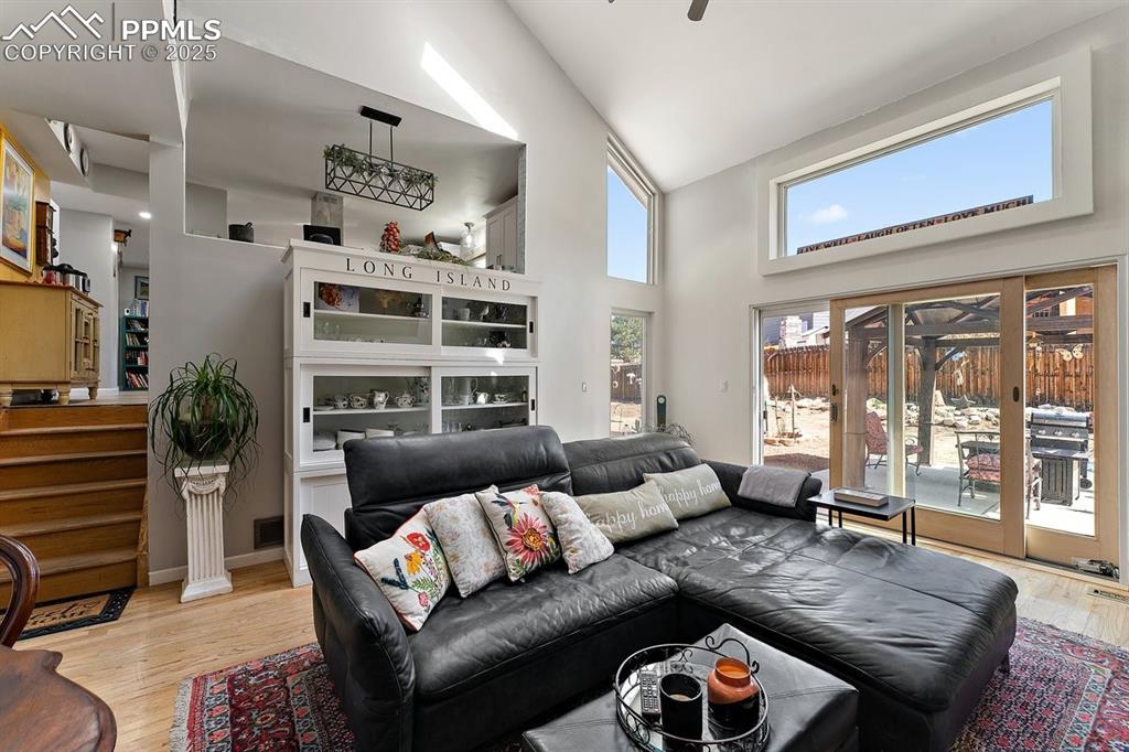Image 21 of 41: Living room featuring high vaulted ceiling, light wood-type flooring, and a