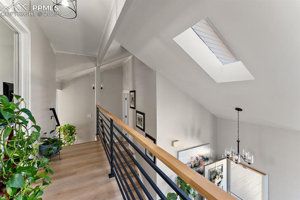 Image 23 of 41: Hall with a skylight, an upstairs landing, vaulted ceiling, light wood-styl