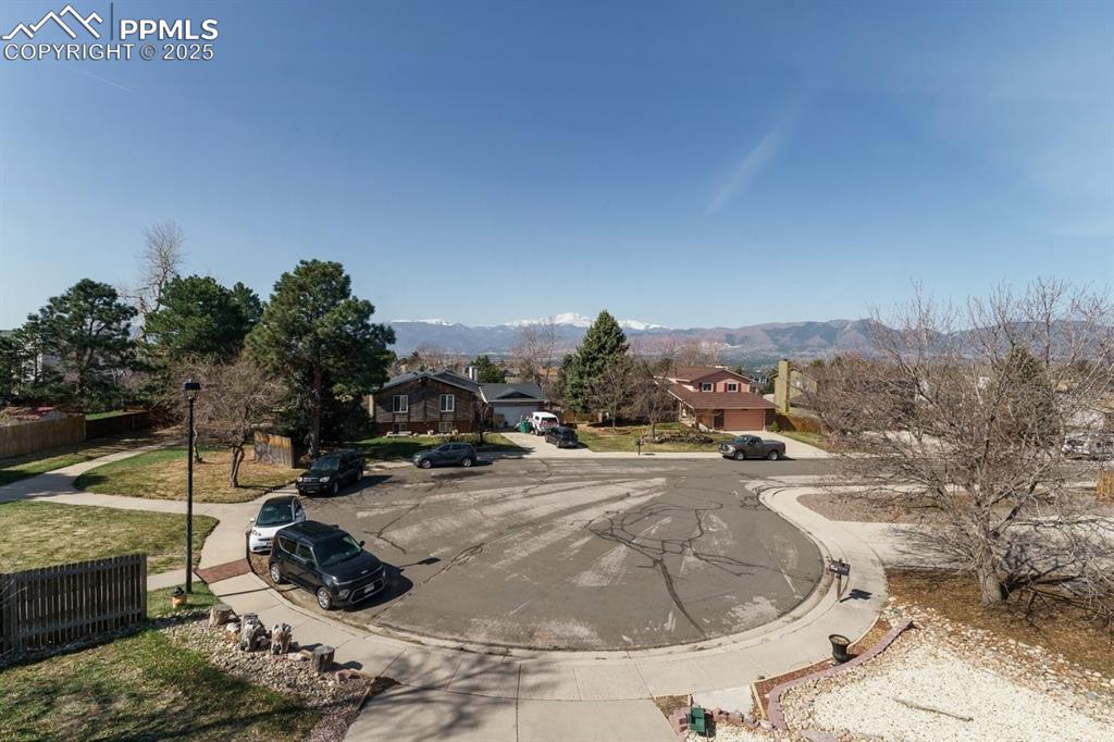Image 38 of 41: View of asphalt road featuring curbs, sidewalks, a mountain view, and stree