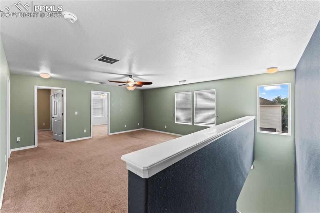 Image 15 of 30: Corridor featuring a textured ceiling and light carpet