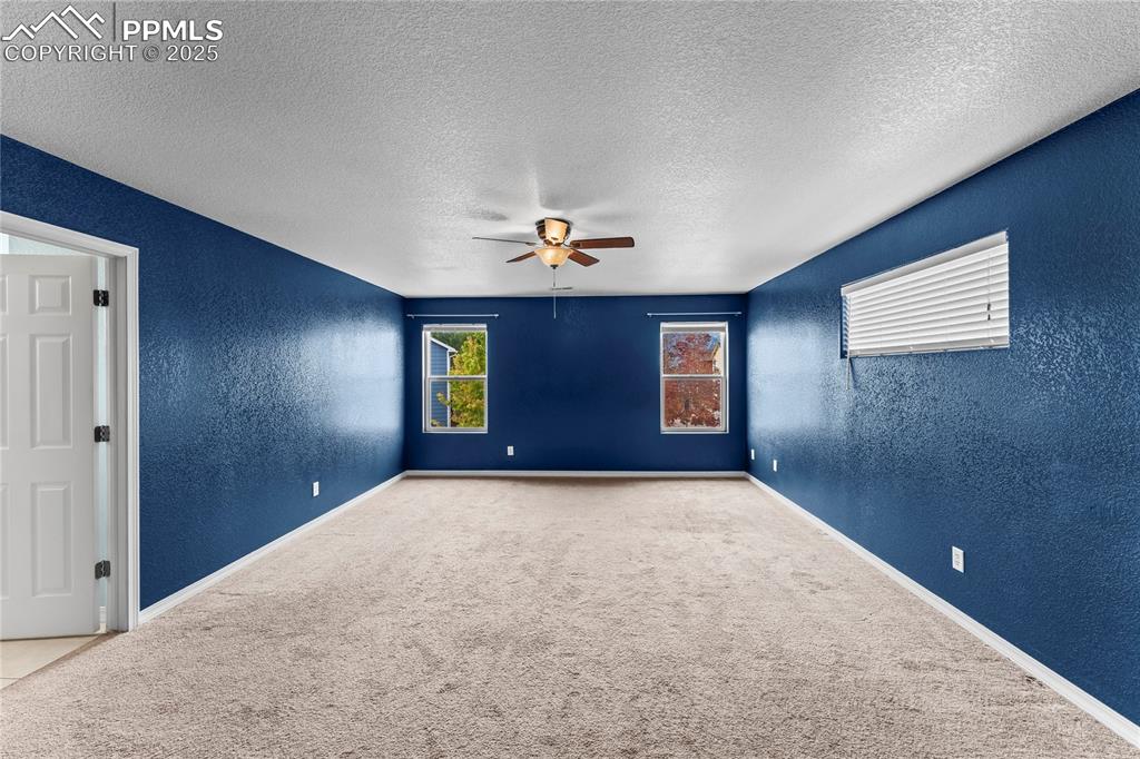 Image 16 of 30: Spare room featuring a textured wall, a textured ceiling, carpet floors, an