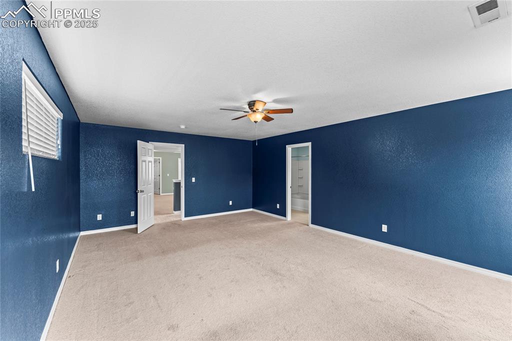 Image 17 of 30: Carpeted spare room with a textured wall and a ceiling fan