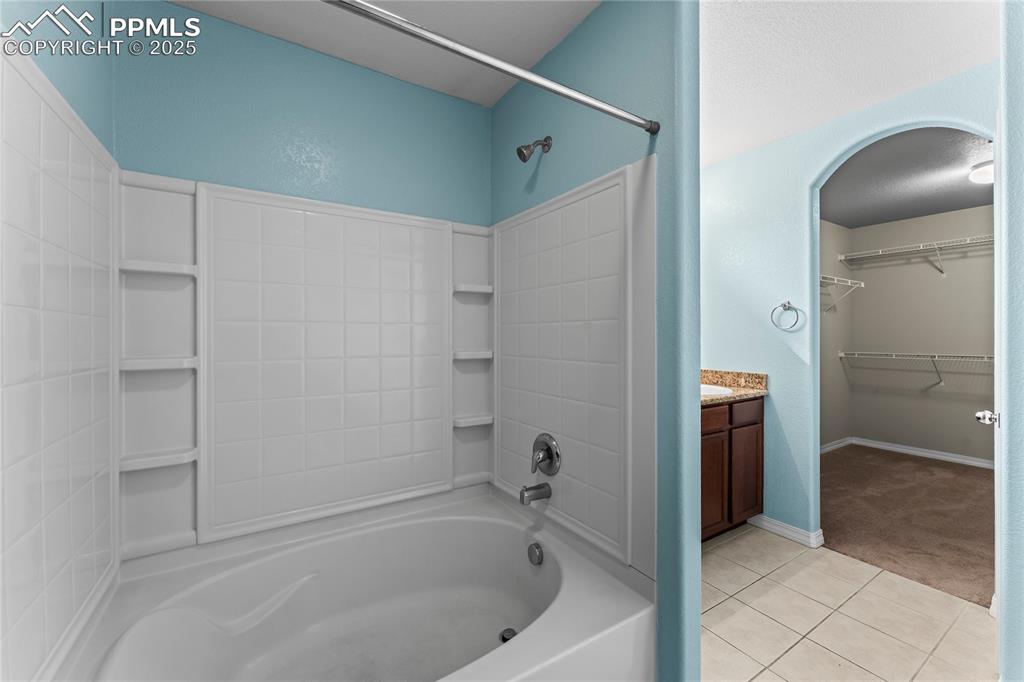 Image 19 of 30: Full bathroom with light tile patterned floors, shower / bath combination, 