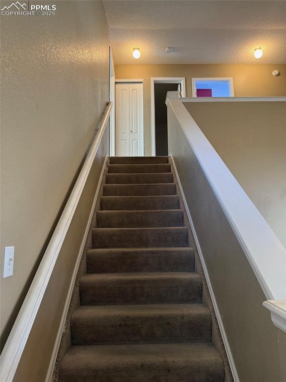 Image 11 of 34: Stairway with a textured ceiling