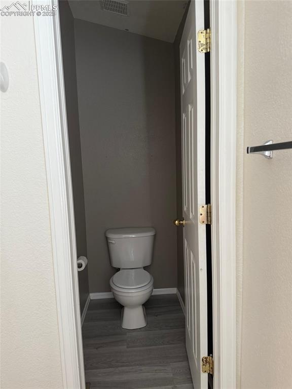 Image 15 of 34: Bathroom featuring toilet, wood finished floors, and baseboards