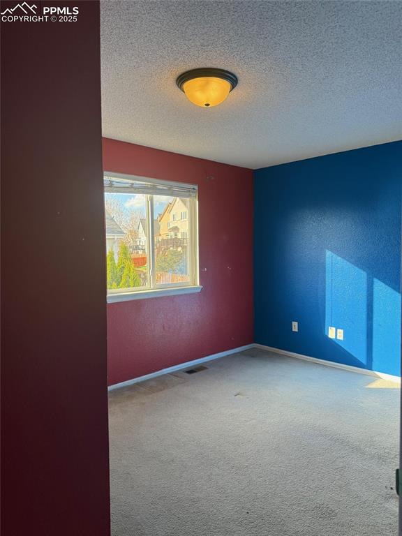 Image 17 of 34: Carpeted spare room with a textured ceiling and baseboards