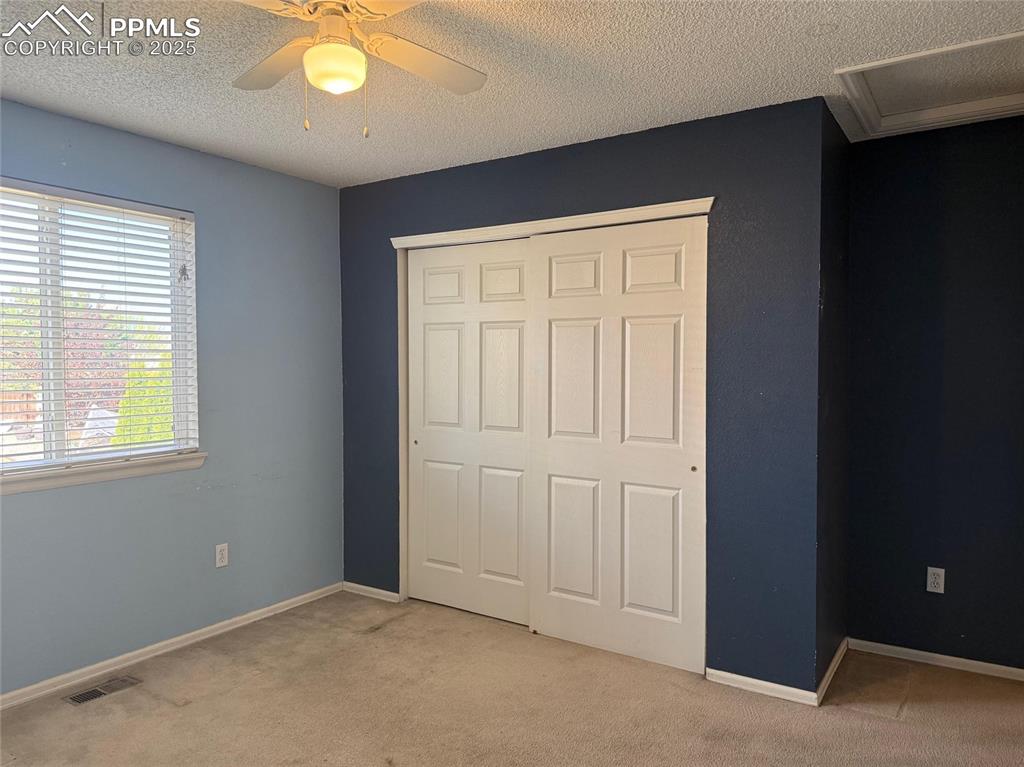 Image 20 of 34: Unfurnished bedroom with light carpet, a closet, a textured ceiling, a ceil