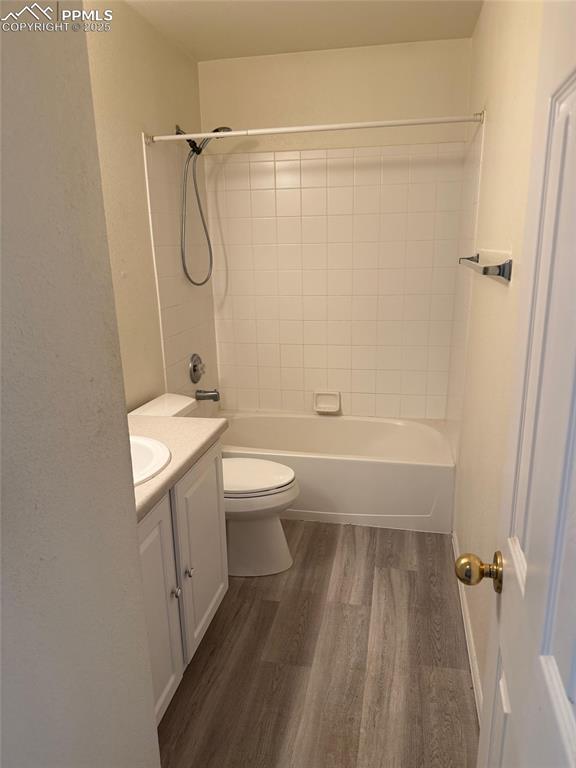 Image 21 of 34: Bathroom with wood finished floors, vanity, toilet, and washtub / shower co