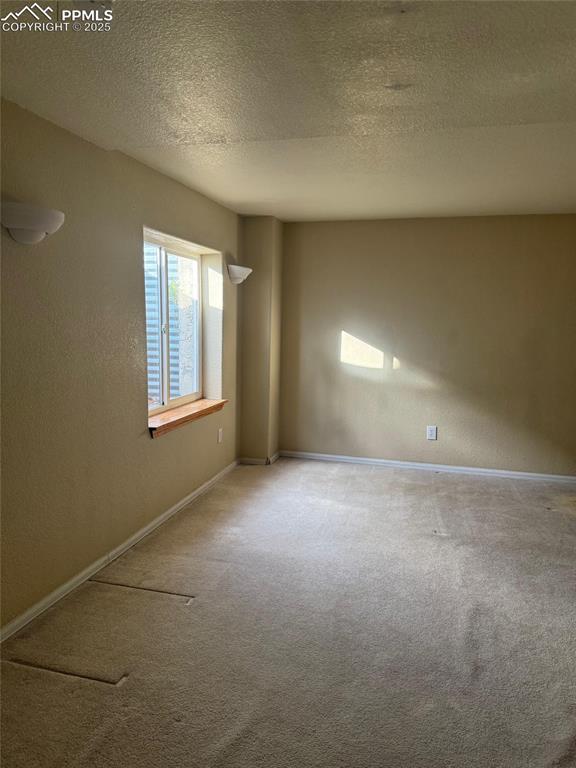 Image 22 of 34: Carpeted empty room featuring baseboards, a textured ceiling, and a texture
