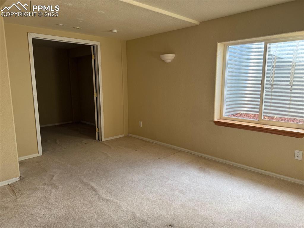 Image 23 of 34: Unfurnished bedroom featuring carpet floors, multiple windows, and baseboar