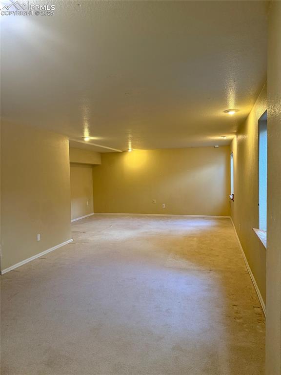 Image 26 of 34: Unfurnished room with light carpet, baseboards, and a textured ceiling