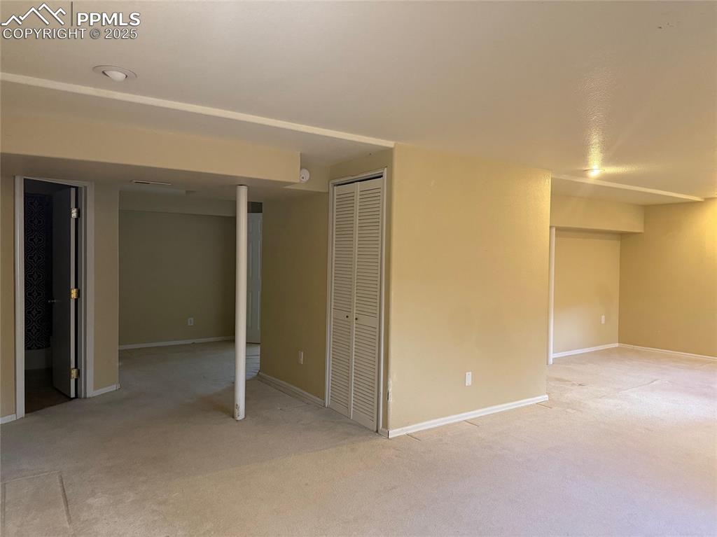 Image 28 of 34: Finished below grade area featuring light carpet and baseboards