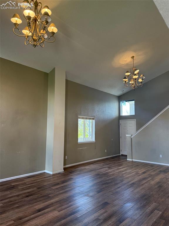 Image 3 of 34: Unfurnished living room with a chandelier, lofted ceiling, plenty of natura