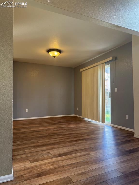 Image 5 of 34: Spare room featuring hardwood / wood-style flooring, baseboards, and a text