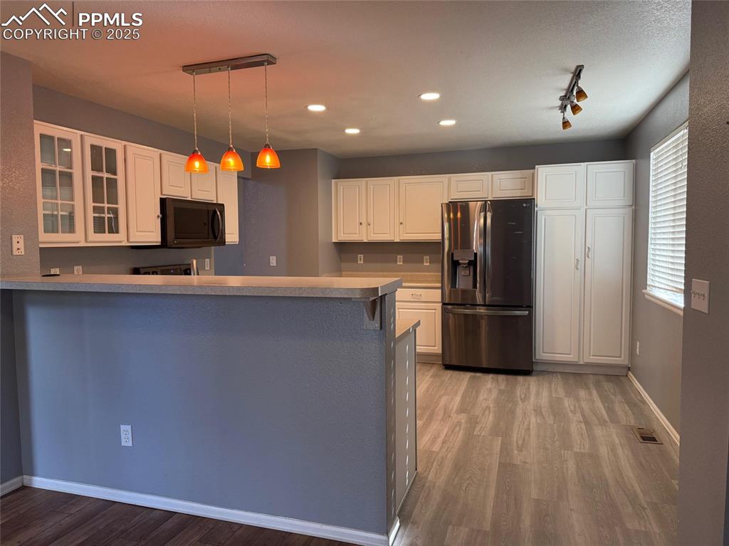 Image 7 of 34: Kitchen featuring stainless steel fridge with ice dispenser, light wood-sty