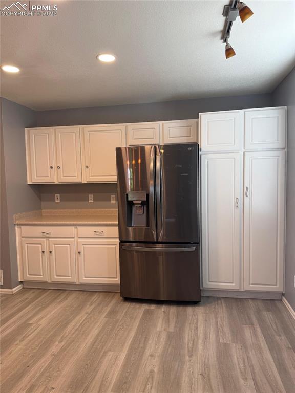 Image 8 of 34: Kitchen featuring stainless steel fridge with ice dispenser, light wood-typ