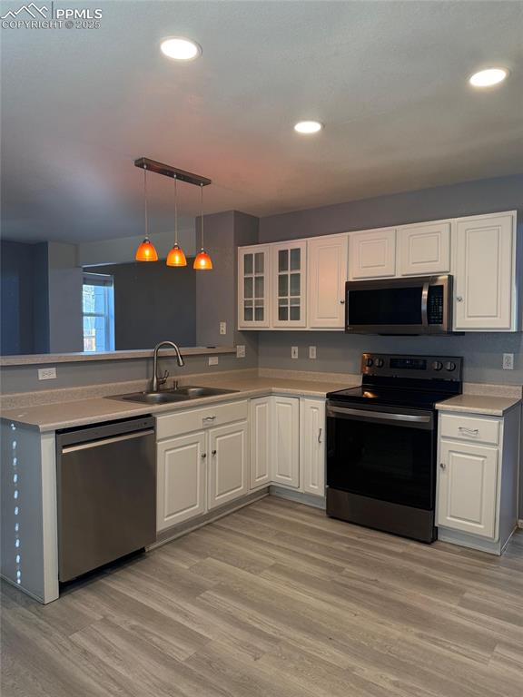 Image 9 of 34: Kitchen featuring appliances with stainless steel finishes, a sink, white c