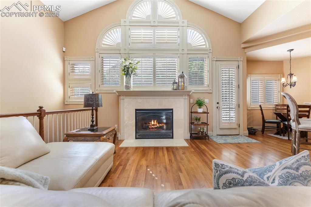 Image 9 of 50: Beautiful large windows fill the room with light and the gas log fireplace 