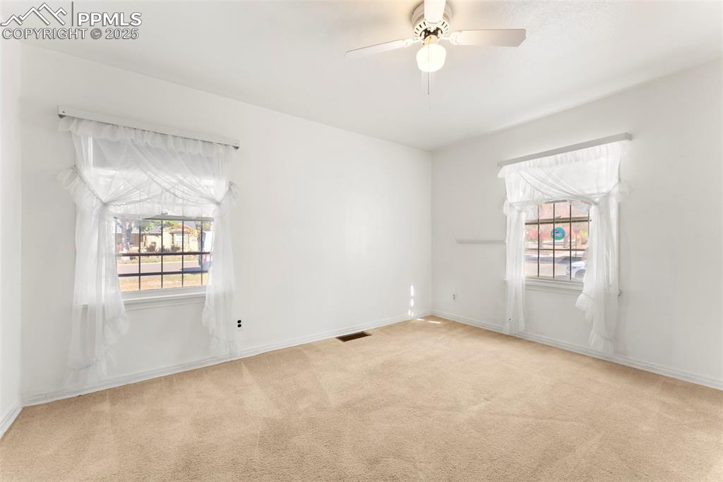 Image 14 of 30: Empty room featuring light colored carpet and ceiling fan