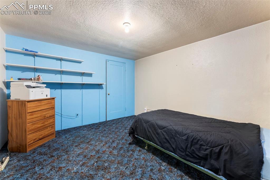 Image 23 of 30: Bedroom featuring dark colored carpet and a textured ceiling