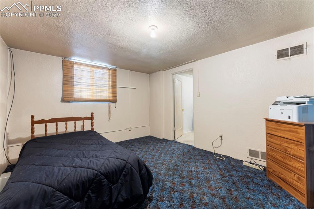Image 24 of 30: Carpeted bedroom with a textured ceiling
