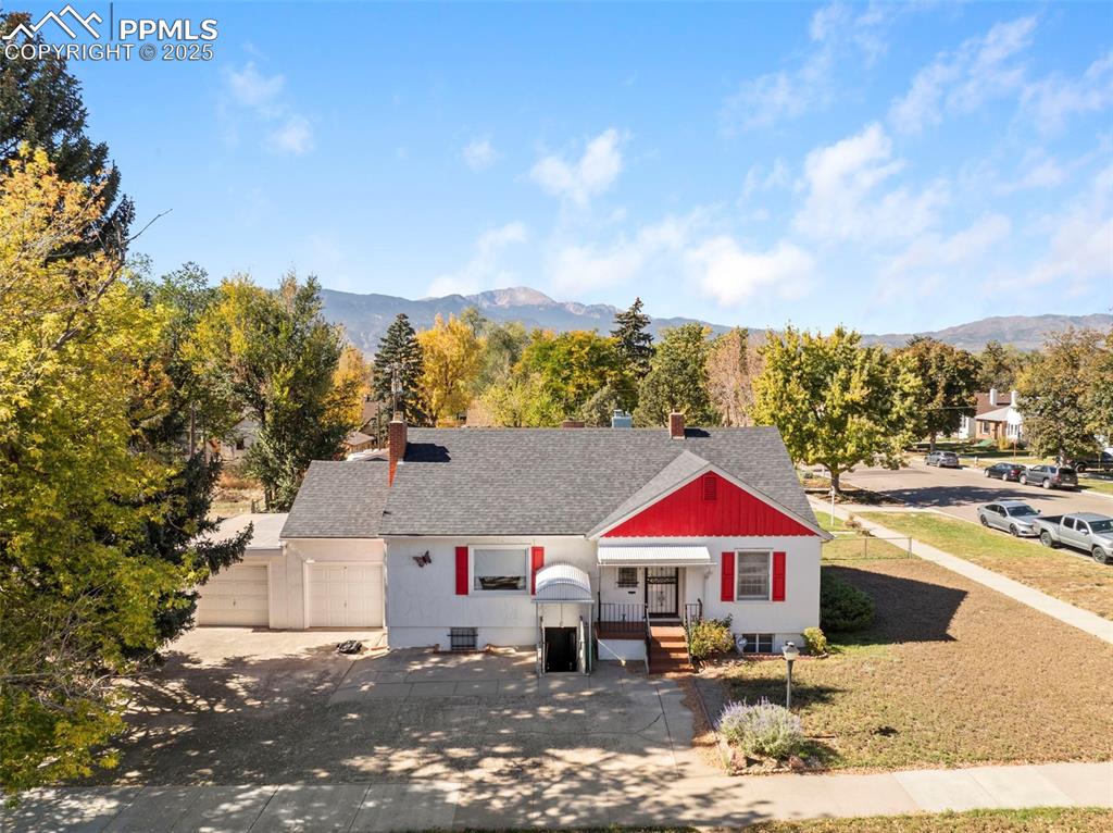 Image 29 of 30: View of front of property featuring covered porch, roof with shingles, driv