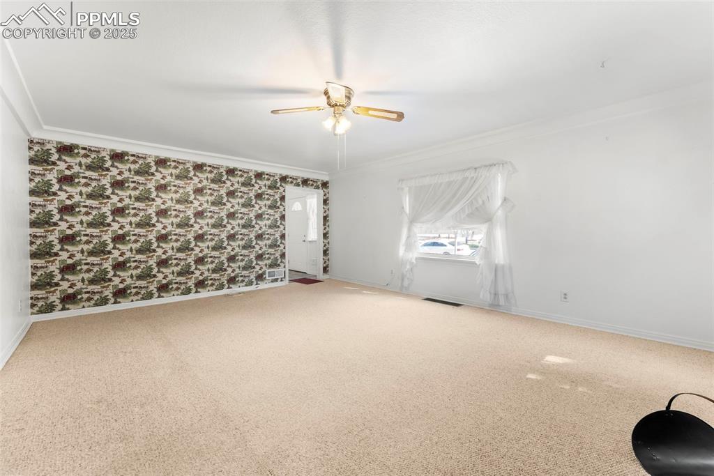 Image 6 of 30: Spare room featuring carpet floors, wallpapered walls, crown molding, and c