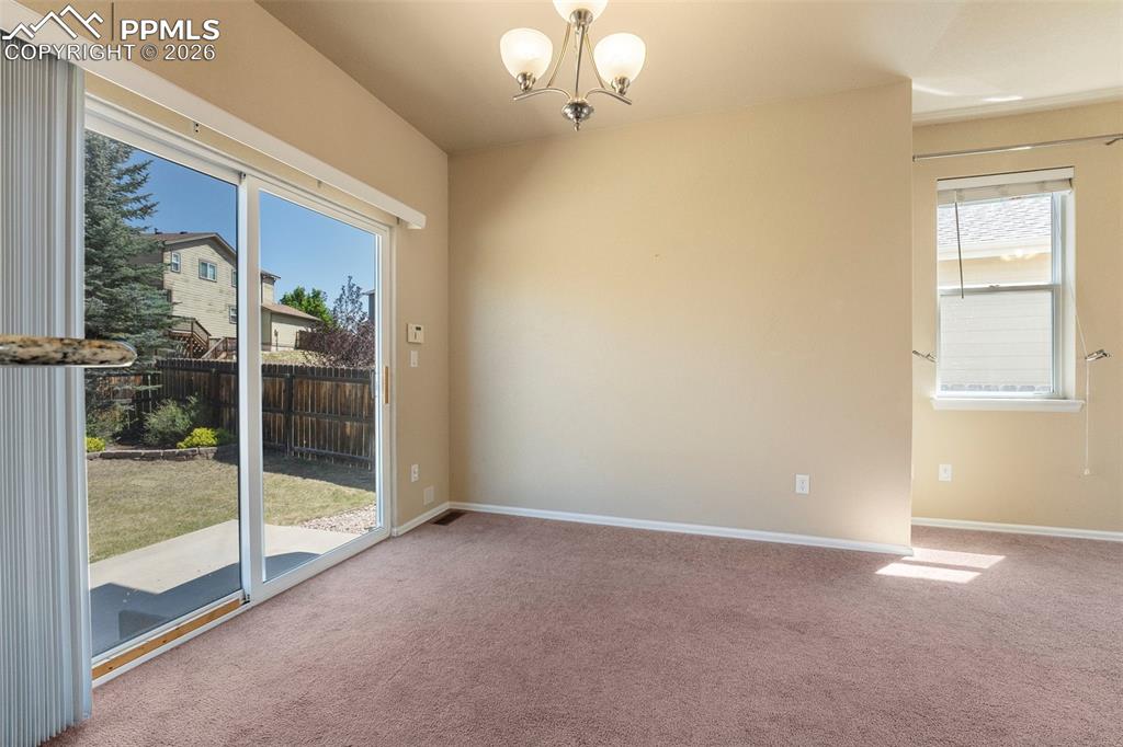 Image 15 of 39: Carpeted dining area with hanging lights and healthy amount of natural ligh