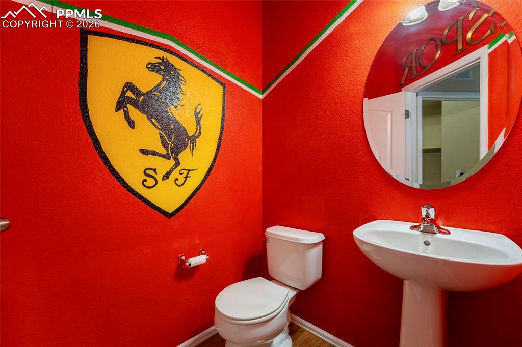 Image 18 of 39: Main level half bath Bathroom featuring accent wall.