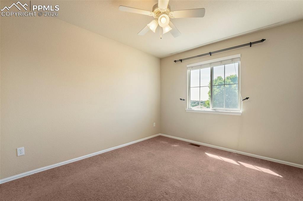 Image 23 of 39: Carpeted empty room with baseboards and a ceiling fan