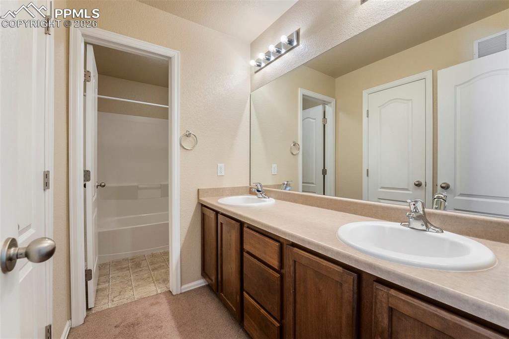 Image 29 of 39: Full bathroom featuring double vanity,  shower combination, and light carpe