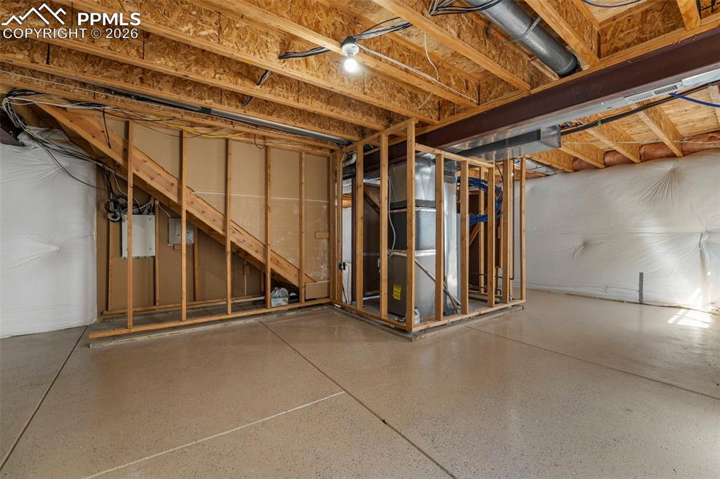 Image 33 of 39: Unfinished below grade area featuring heating unit and electric panel