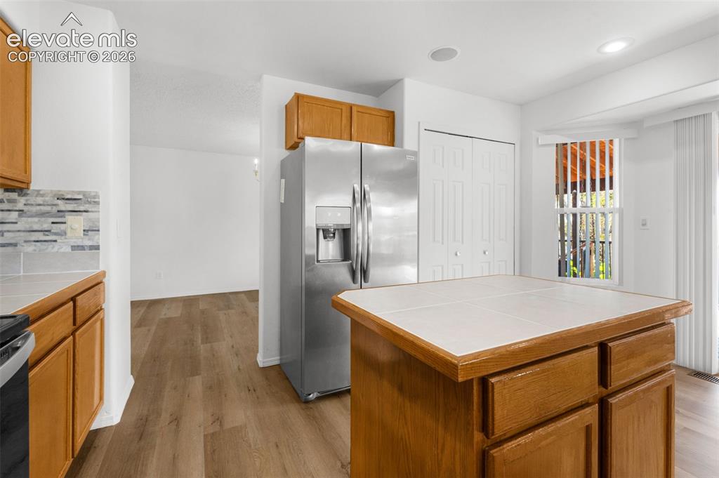 Image 15 of 48: Kitchen featuring a stainless steel French door refrigerator, wood cabinetr
