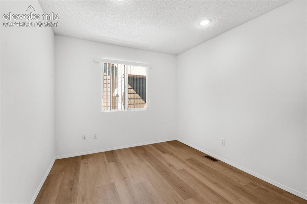 Image 17 of 48: Recessed lighting fixtures, window with vertical blinds, wood-finish floori