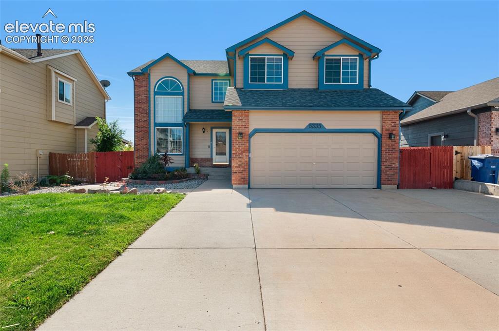 Image 2 of 48: Two-story residence featuring brick accents, an arched window, and a dual-d