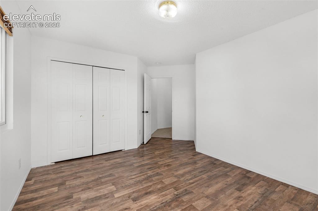 Image 26 of 48: Wood-finish flooring with white walls and bi-fold closet doors