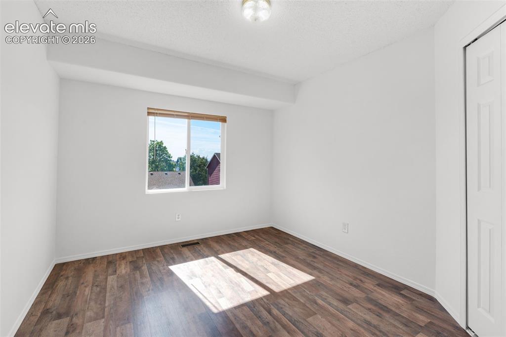 Image 27 of 48: Recessed window with wood-tone blinds, wood-finish flooring, overhead flush