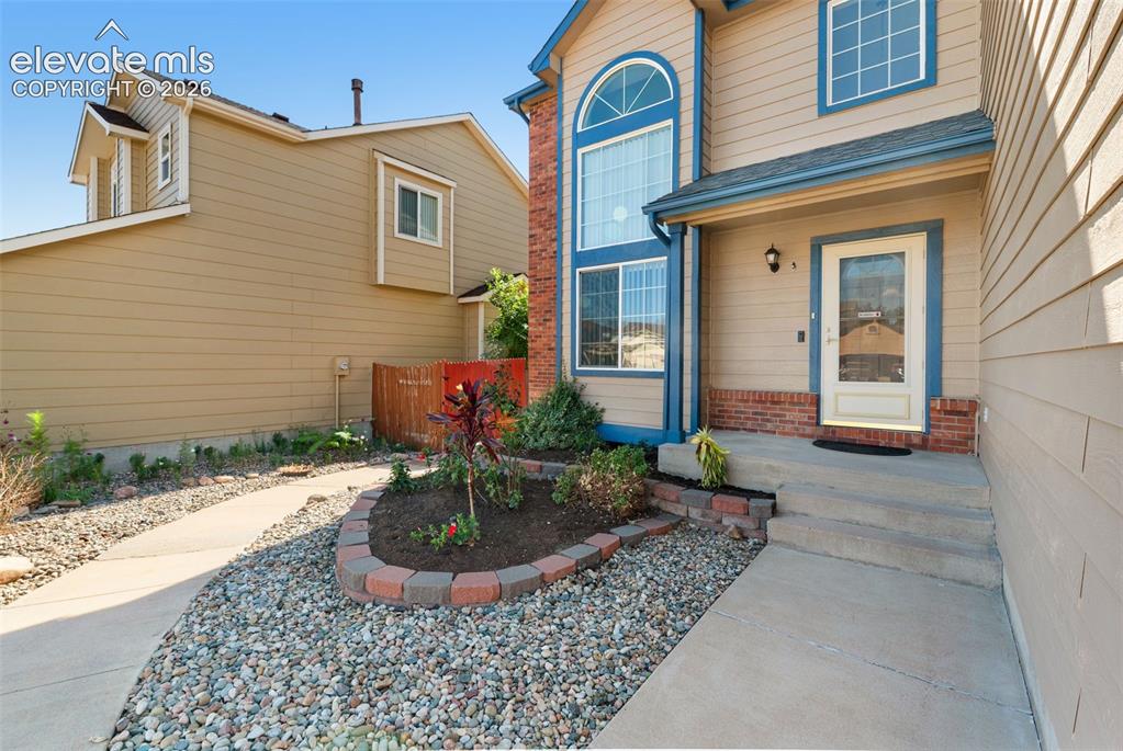 Image 3 of 48: Beige siding exterior with blue trim accents and a partial brick facade